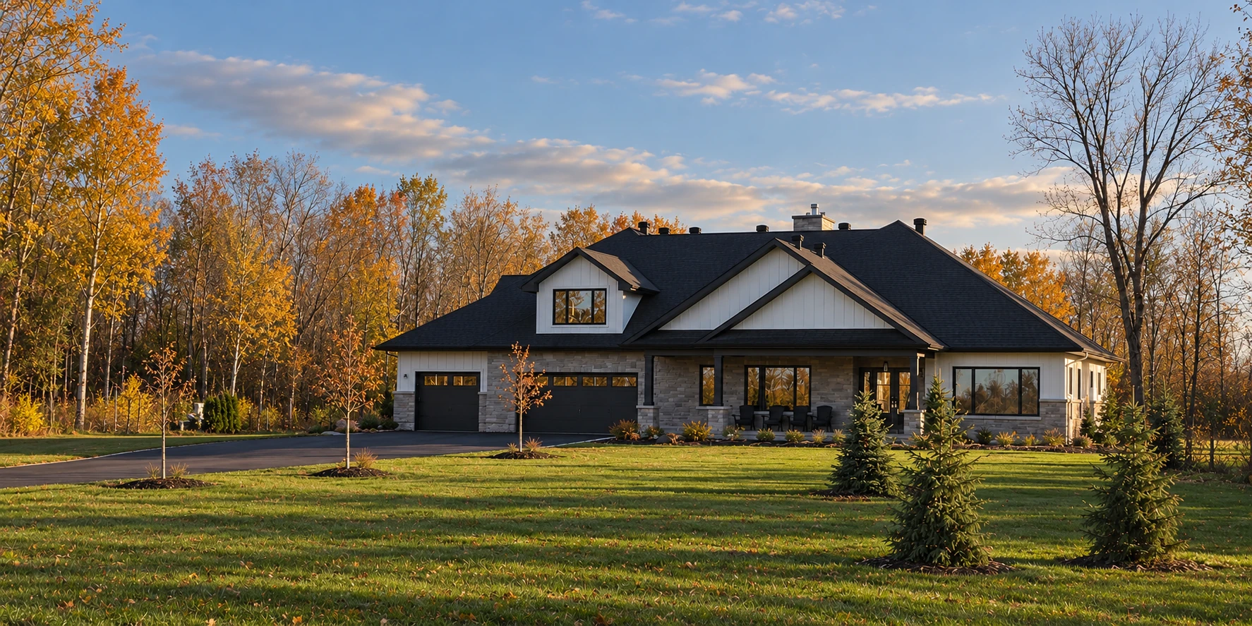 Our custom-built stone and white-sided home in soft afternoon light, with young oaks along the laneway and subtly enhanced landscaping and sky
